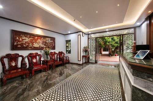 a living room with chairs and a painting on the wall at Nam Hai Hotel in Hanoi