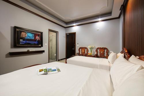 a bedroom with a bed with a tv on the wall at Nam Hai Hotel in Hanoi