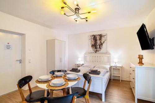 a living room with a table and chairs and a bed at Aposto Apartments 1 in Oberderdingen