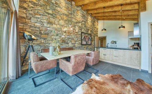 a kitchen with a table and chairs and a stone wall at AlpenParks Hotel & Apartment Sonnleiten in Saalbach-Hinterglemm