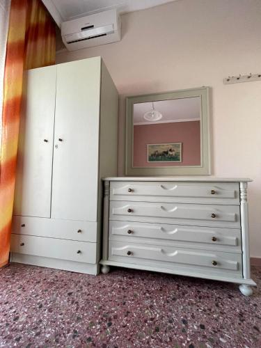 a bedroom with a dresser and a mirror at Hotel Angela in Asprovalta