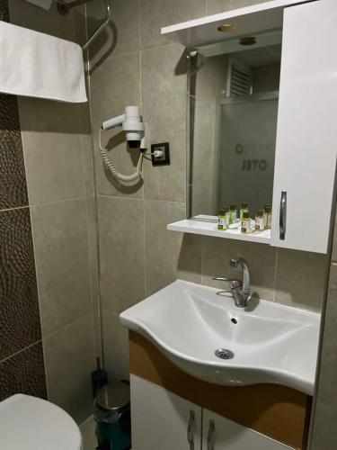 a bathroom with a sink and a shower at Metro Otel in İzmir