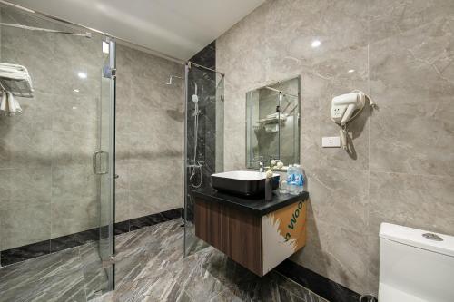 y baño con ducha y lavamanos. en Nam Hai Hotel en Hanói