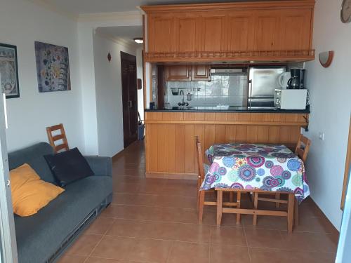 プラヤ・デ・ラス・アメリカスにあるLas Americas bonita vista 61のリビングルーム(ソファ、テーブル付)、キッチンが備わります。