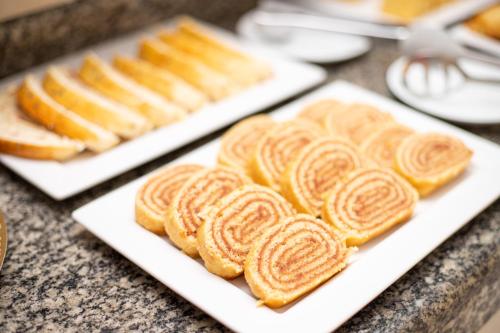 two white plates with pastries on top of a counter at Pousada Mariluz in Maragogi