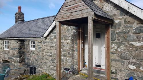 a stone house with a wooden frame around the door at Grade II Lodge House 2 Bedroom in Trawsfynydd