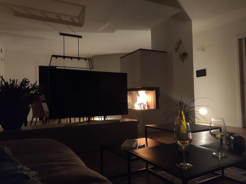 a living room with a couch and a tv at Casa Riccardo in Levico Terme