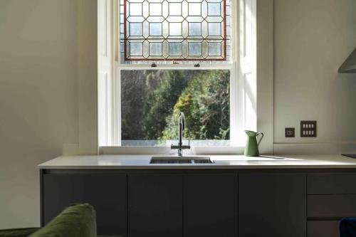 a kitchen with a sink and a window at Stylish Sea View Apartment in Torquay