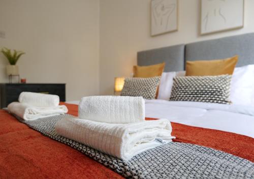 a bedroom with two beds with towels on the bed at Modern Spark Home with parking, garden, Wi-Fi in Birmingham