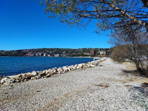 a rocky beach next to a body of water at SEA LUX FLOATING HOUSE AJDA Portorose in Portorož