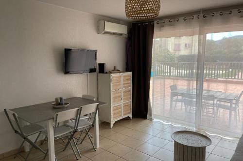 une salle à manger avec une table et un balcon dans l'établissement 46m with terrace - residence with pool, à Porto-Vecchio