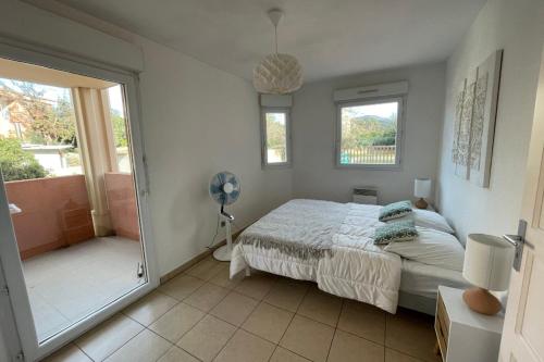 - une chambre avec un lit et une porte donnant sur un balcon dans l'établissement 46m with terrace - residence with pool, à Porto-Vecchio