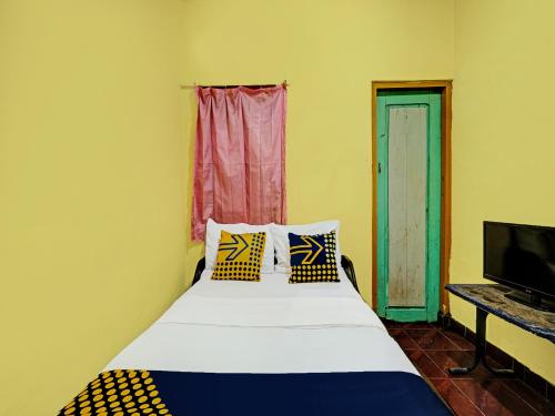 - une chambre avec un lit doté d'oreillers et une télévision dans l'établissement SPOT ON 92414 Hotel Pereng Sari, à Kopeng