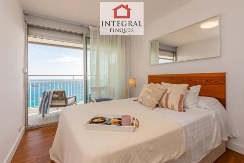 a bedroom with a bed with a view of the ocean at La Belle Mer Palamós in Palamós