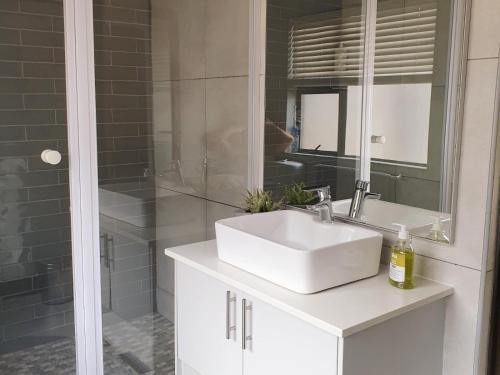 a bathroom with a white sink and a shower at Studio's@360onChurch in Pretoria