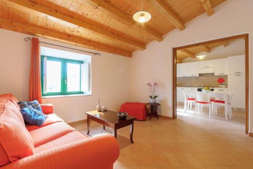 a living room with a red couch and a table at Vito nel Baglio in Scopello