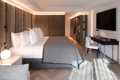 a hotel room with a large bed and a desk at Hotel MIM Andorra in Escaldes-Engordany