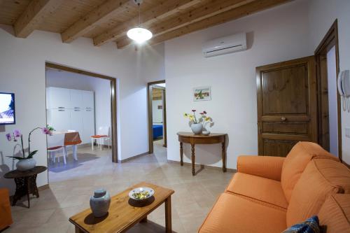 a living room with an orange couch and a table at Vito nel Baglio in Scopello