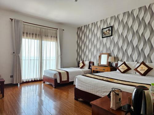 ein Hotelzimmer mit 2 Betten und einer gestreiften Wand in der Unterkunft Venus Phu Quoc Hotel in Phu Quoc