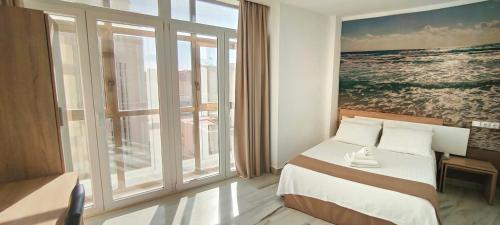 アルメリアにあるHotel Sol Almeríaのベッドと大きな窓が備わるホテルルームです。