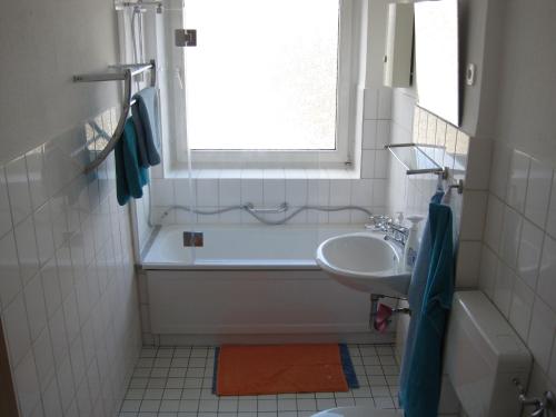 ein Badezimmer mit Badewanne und Waschbecken und einem Fenster in der Unterkunft Bahnhofstr Apartment in Castrop-Rauxel