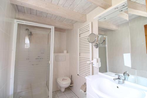 La salle de bains blanche est pourvue de toilettes et d'un lavabo. dans l'établissement Kummerower Hof, à Neuzelle