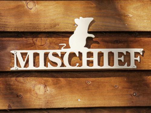 a sign for a museum on a wooden wall at Mischief in Harpham