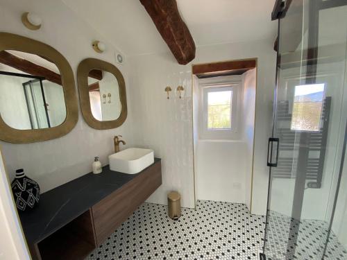 ein Bad mit einem Waschbecken und einem Spiegel in der Unterkunft Maison Albertine in Creissels