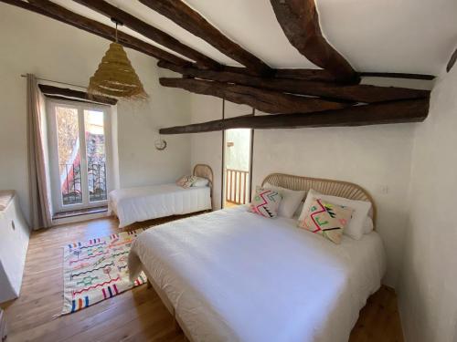 a bedroom with a large white bed and a window at Maison Albertine in Creissels