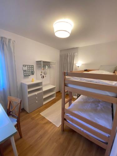1 dormitorio con 2 literas y escritorio en Christl - Apartment mit Garten und Pool zur Mitbenutzung en Viena