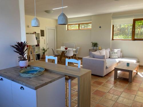 a kitchen and living room with a couch and a table at Minoa apartment in the heart of a Cretan village in Atsipopoulo