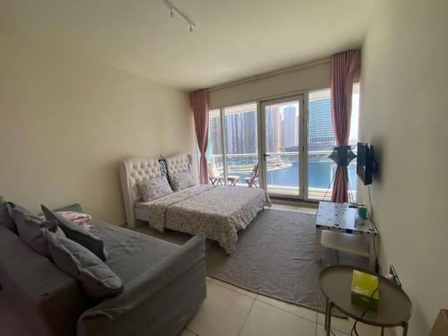 uma sala de estar com um sofá e uma grande janela em Waking up with the sea view! em Dubai