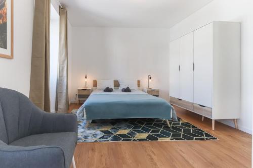 シントラにあるSintra Flower Lux Apartmentsのベッドルーム1室(ベッド1台、ソファ、椅子付)