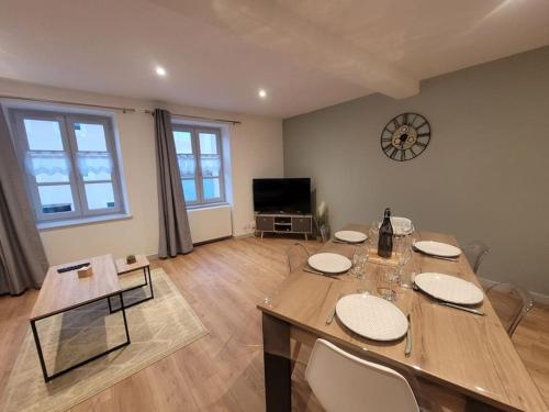 een eetkamer met een tafel en een klok aan de muur bij Appartement Le Duplex in Cluny