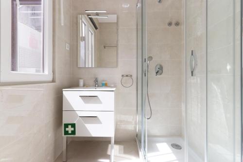 bagno bianco con doccia e lavandino di Sintra Flower Lux Apartments a Sintra