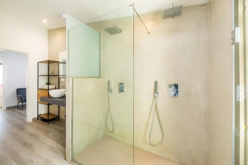 uma casa de banho com um chuveiro e uma porta de vidro em Cas Juniors em Santa Margalida
