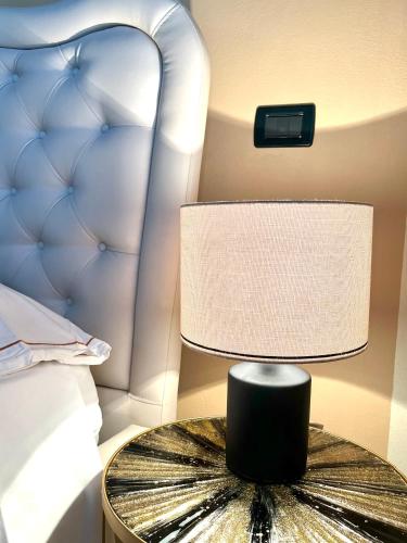 a lamp on a table next to a bed at Residence la Lucciola in Lonato del Garda