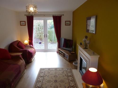 a living room with a couch and a tv and a fireplace at Hendre Wen luxury cottage in Betws y Coed in Betws-y-coed