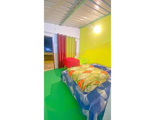 Oakland Camping, Uttarkashi في Uttarkāshi: غرفة نوم مع سرير في غرفة مع جدران ملونة