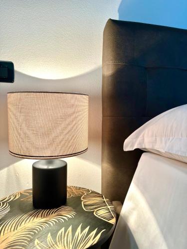a lamp sitting on a table next to a bed at Residence la Lucciola in Lonato del Garda