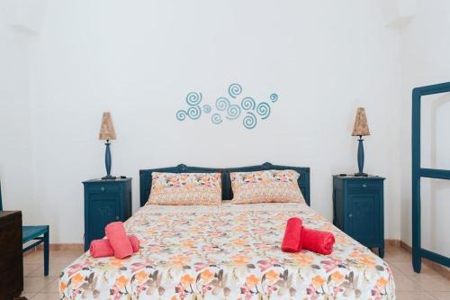 ein Schlafzimmer mit einem großen Bett mit roten Kissen in der Unterkunft Nel Cuore del Salento, La Casa del Geco, Elegante Villa d’epoca in Ugento