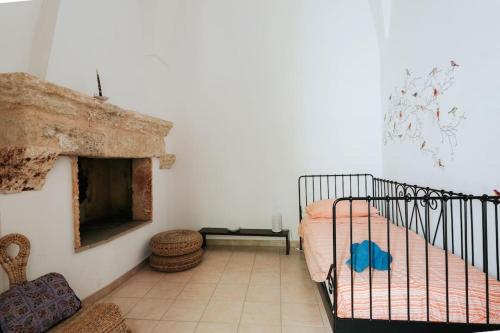 ein Schlafzimmer mit einem Bett und einem Kamin in der Unterkunft Nel Cuore del Salento, La Casa del Geco, Elegante Villa d’epoca in Ugento