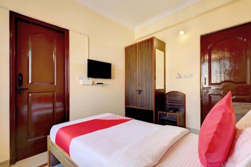 a hotel room with a bed and a television at OYO Flagship Sunder Nivas in Bangalore