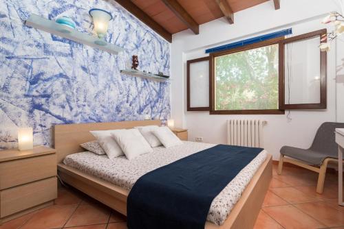 ein Schlafzimmer mit einem Bett und einer blau-weißen Tapete in der Unterkunft Casa Angela in Capdepera