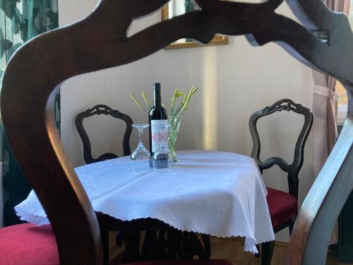 a table with a bottle of wine and two chairs at ApartmentVillaSolomon7 - Dunakanyar Apartman Visegrád Panorámás in Visegrád