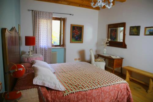 a bedroom with a bed and a table and a window at Agriturismo alle Torricelle in Verona