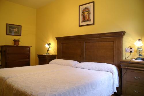 a bedroom with a large bed and two dressers at La Casa Verde del Sella in Mesariegos