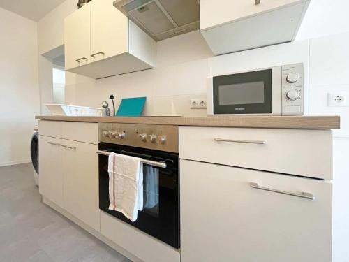 a kitchen with a stove and a microwave at Chic & Modern Apartments in Eberswalde in Eberswalde