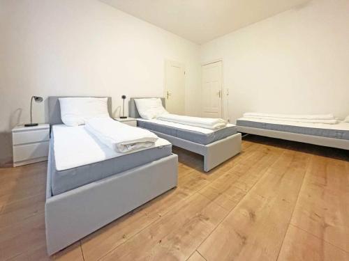 two beds in a room with wooden floors at Chic & Modern Apartments in Eberswalde in Eberswalde