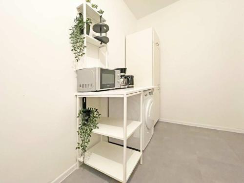 a kitchen with a white shelf with a microwave at Chic & Modern Apartments in Eberswalde in Eberswalde